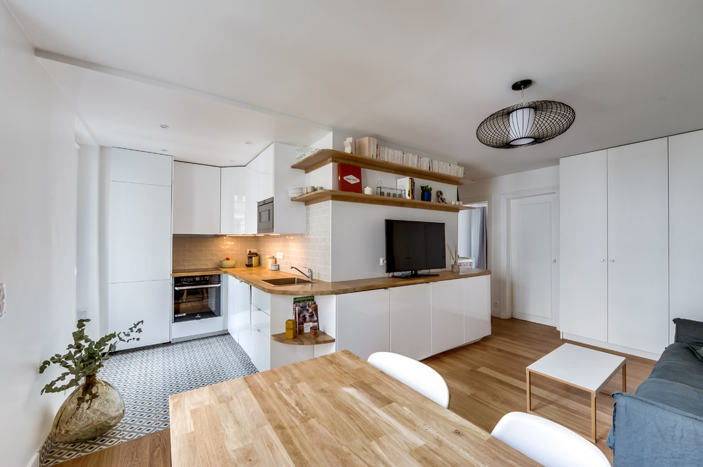 Стильный дизайн: гостиная комната в современном стиле с белыми стенами, светлым паркетным полом и отдельно стоящим телевизором без камина - последний тренд