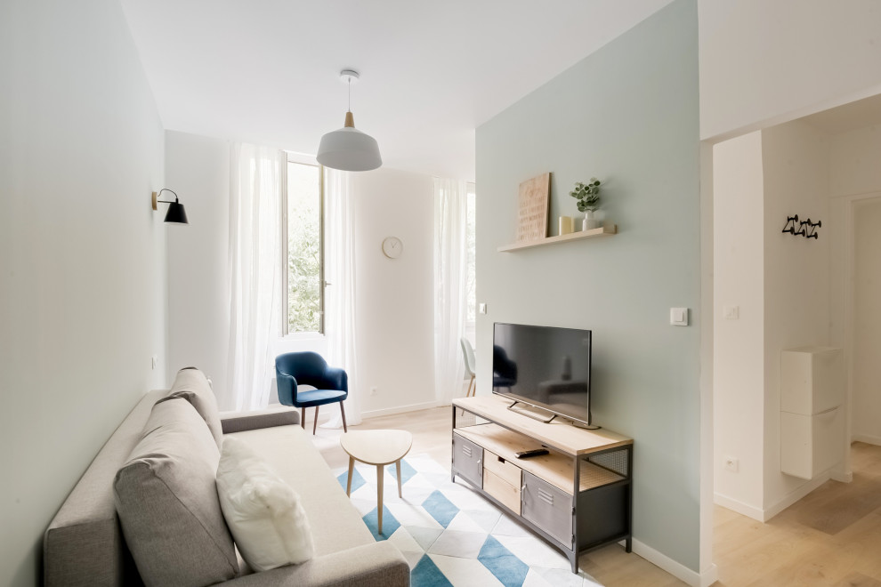 Aménagement d'un petit salon scandinave ouvert avec un mur bleu, sol en stratifié et un sol marron.