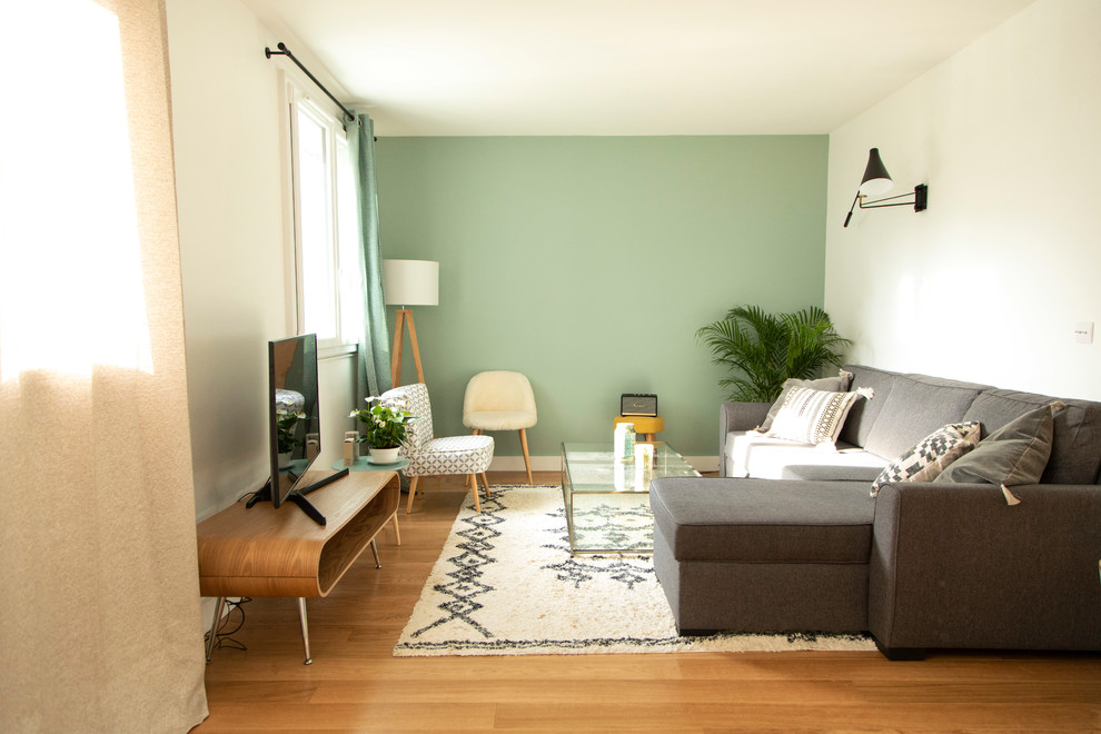 Foto di un piccolo soggiorno moderno aperto con pareti verdi, pavimento in legno massello medio, nessun camino, TV autoportante e pavimento marrone