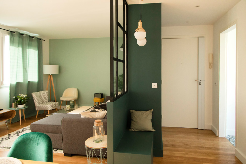 Esempio di un piccolo soggiorno moderno aperto con pareti verdi, pavimento in legno massello medio, nessun camino, TV autoportante e pavimento marrone
