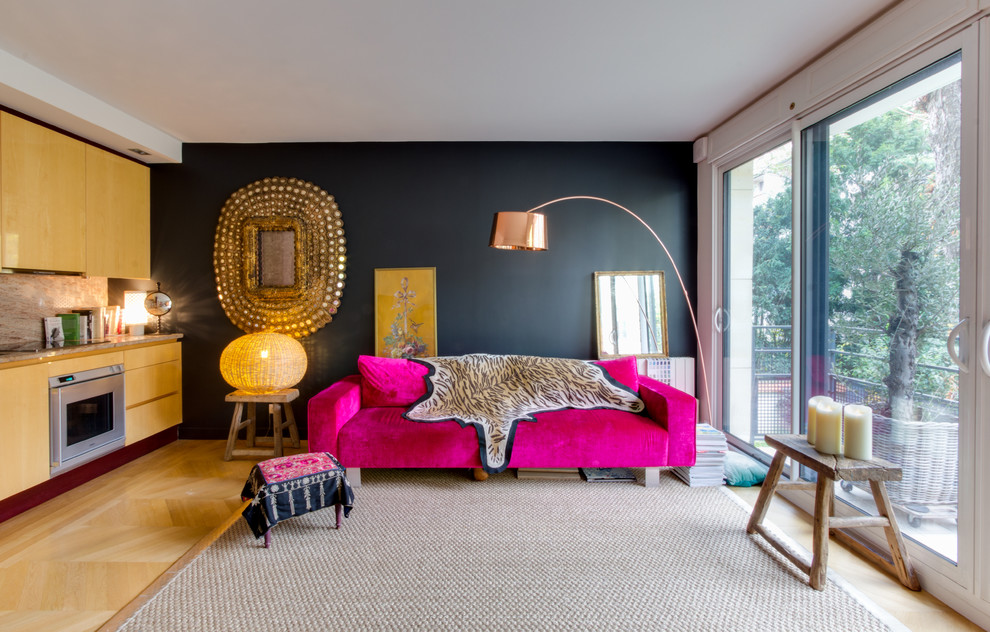 Ejemplo de salón para visitas abierto bohemio de tamaño medio sin chimenea y televisor con paredes negras y suelo de madera en tonos medios