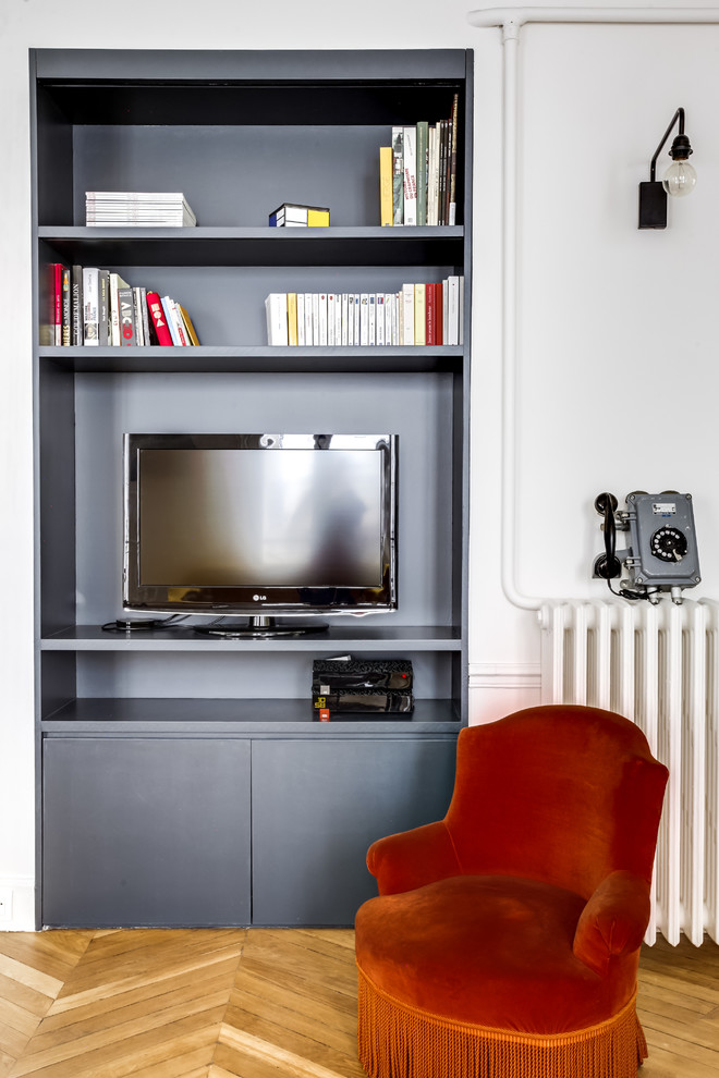 Immagine di un soggiorno contemporaneo aperto con libreria, pareti bianche, parquet chiaro, camino ad angolo e TV autoportante