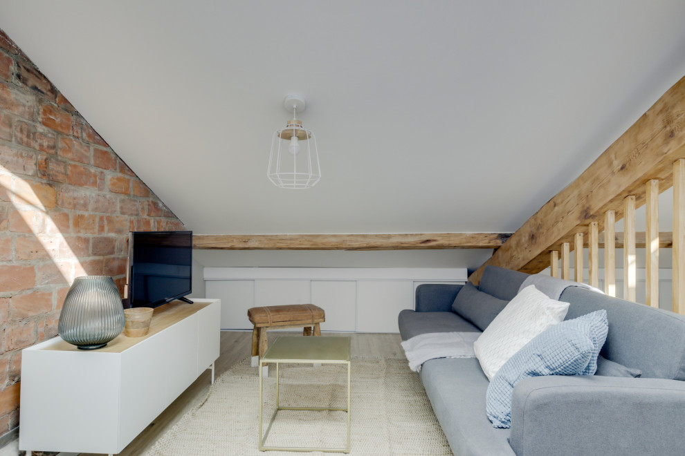 Modelo de salón tipo loft nórdico pequeño con paredes multicolor, suelo de madera clara, marco de chimenea de ladrillo, vigas vistas y madera