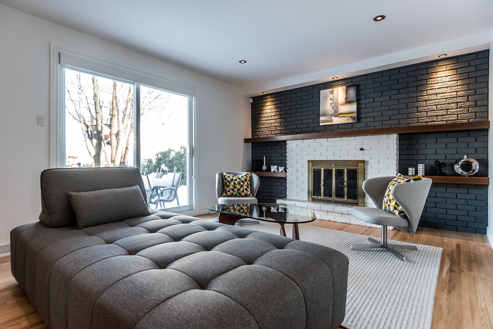 Inspiration for a contemporary formal enclosed living room in Montreal with multi-coloured walls, light hardwood flooring, a standard fireplace and a brick fireplace surround.