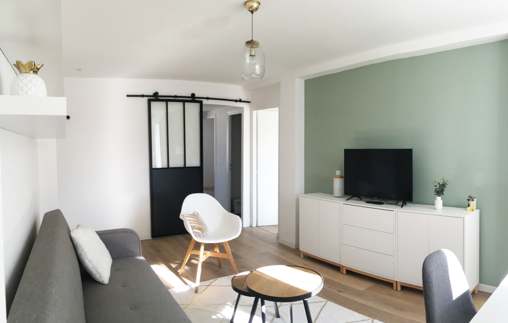 Design ideas for a small scandi open plan living room in Marseille with green walls, laminate floors and brown floors.