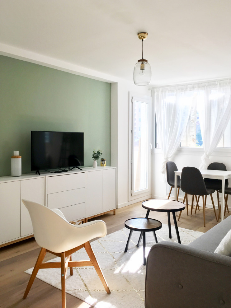 Imagen de salón abierto nórdico pequeño con paredes verdes, suelo laminado y suelo marrón