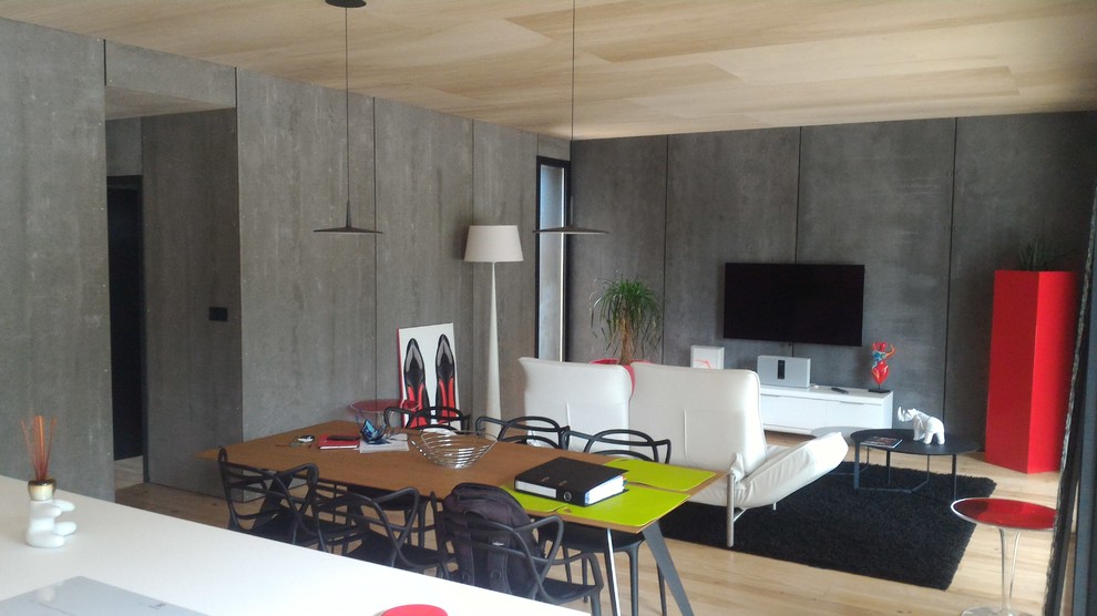 Industriell inredning av ett mellanstort separat vardagsrum, med grå väggar, ljust trägolv, en väggmonterad TV, beiget golv och en hemmabar