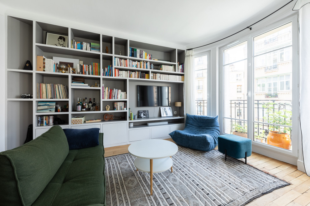 Mittelgroße, Abgetrennte Nordische Bibliothek ohne Kamin mit weißer Wandfarbe, hellem Holzboden, Multimediawand und beigem Boden in Paris