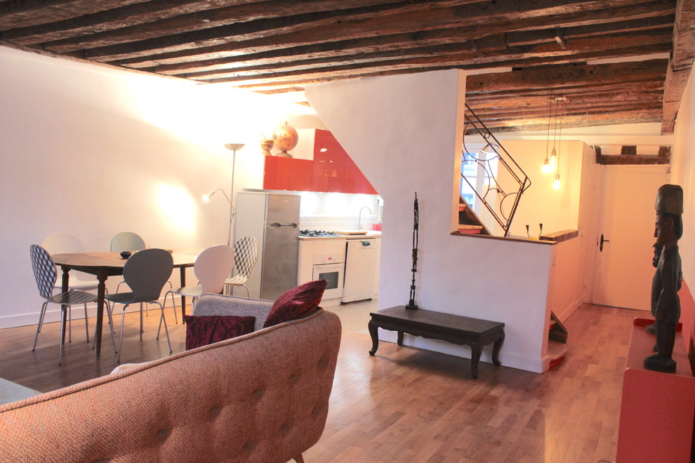 Medium sized world-inspired living room in Paris with orange walls and medium hardwood flooring.