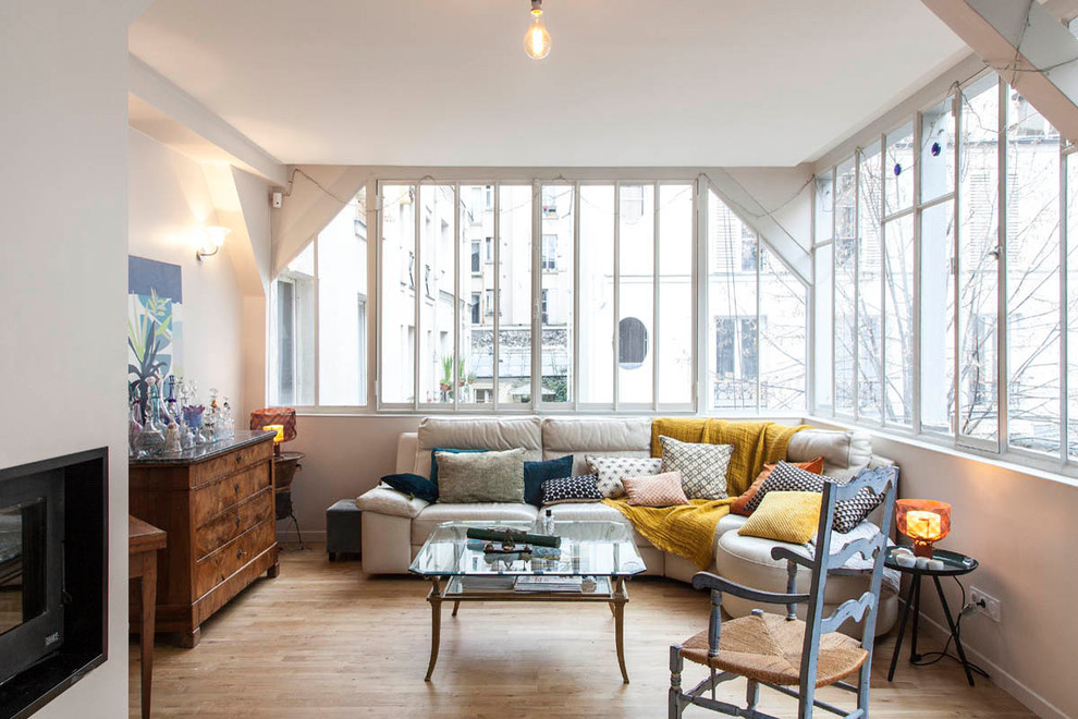 Repräsentatives, Abgetrenntes Eklektisches Wohnzimmer mit beiger Wandfarbe, hellem Holzboden, Gaskamin und beigem Boden in Paris