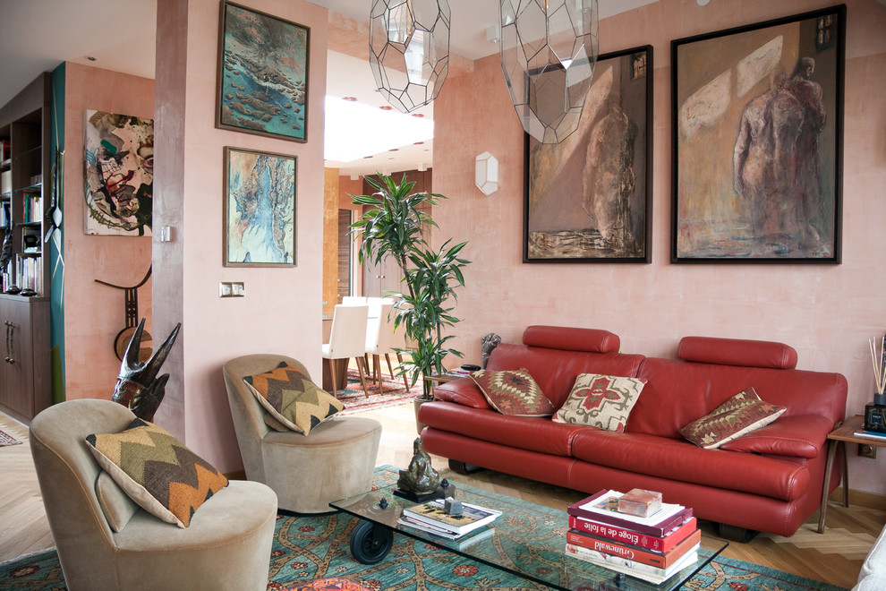 Bild på ett medelhavsstil allrum med öppen planlösning, med rosa väggar och ljust trägolv