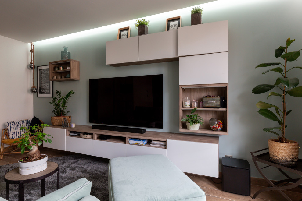 На фото: маленькая открытая гостиная комната в современном стиле с зелеными стенами, полом из керамической плитки, телевизором на стене и коричневым полом без камина для на участке и в саду