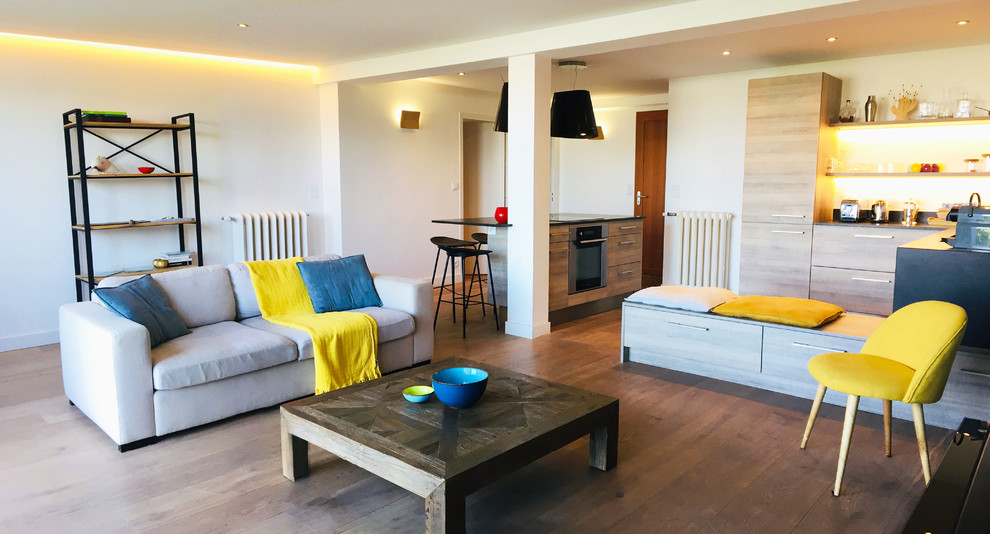 Großes, Offenes Modernes Wohnzimmer ohne Kamin mit weißer Wandfarbe, braunem Holzboden, TV-Wand und braunem Boden in Rennes