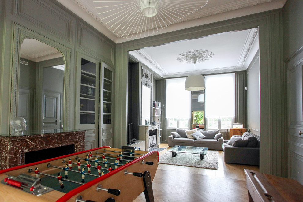 Foto di un soggiorno classico di medie dimensioni e aperto con sala formale, pareti verdi, parquet chiaro, camino classico e TV autoportante