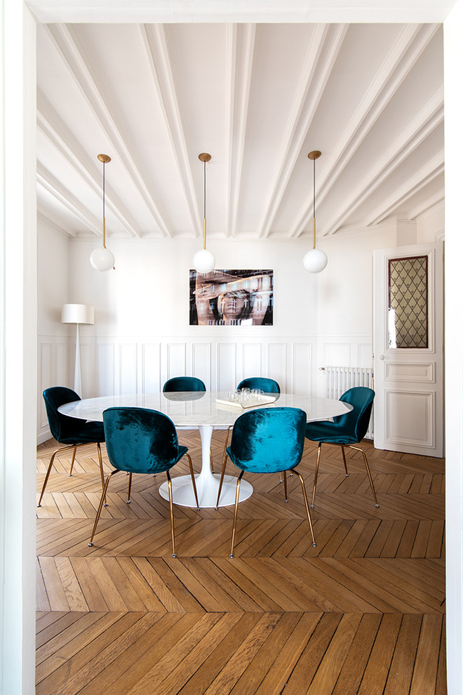 Idee per una sala da pranzo tradizionale di medie dimensioni con pareti bianche, pavimento in legno massello medio, pavimento marrone, camino classico e cornice del camino in pietra