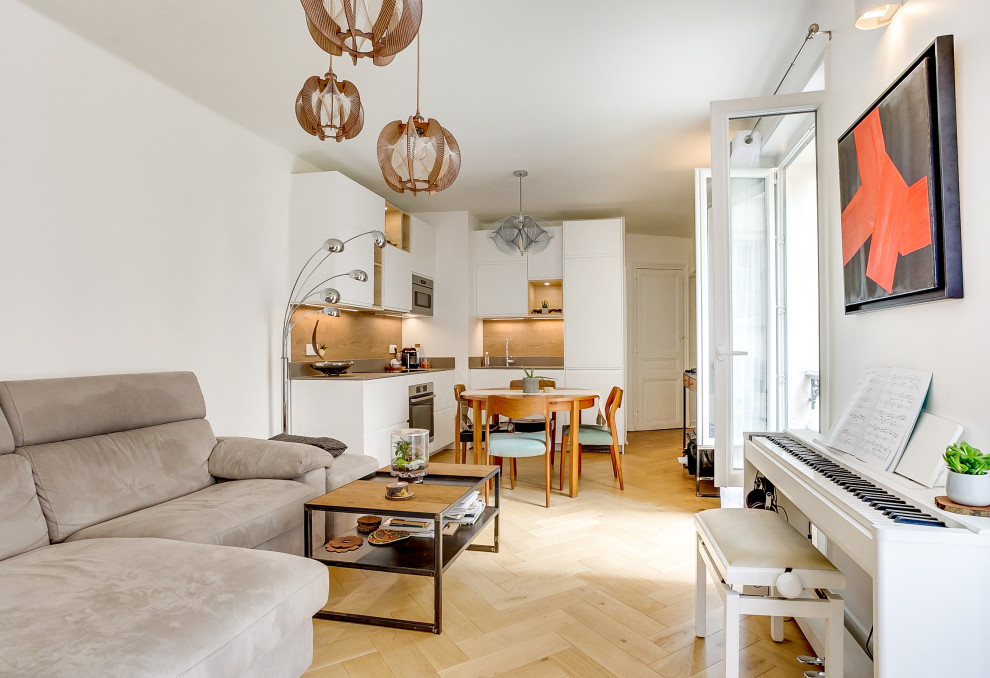 Kleines, Offenes Modernes Wohnzimmer mit weißer Wandfarbe, hellem Holzboden und braunem Boden in Paris
