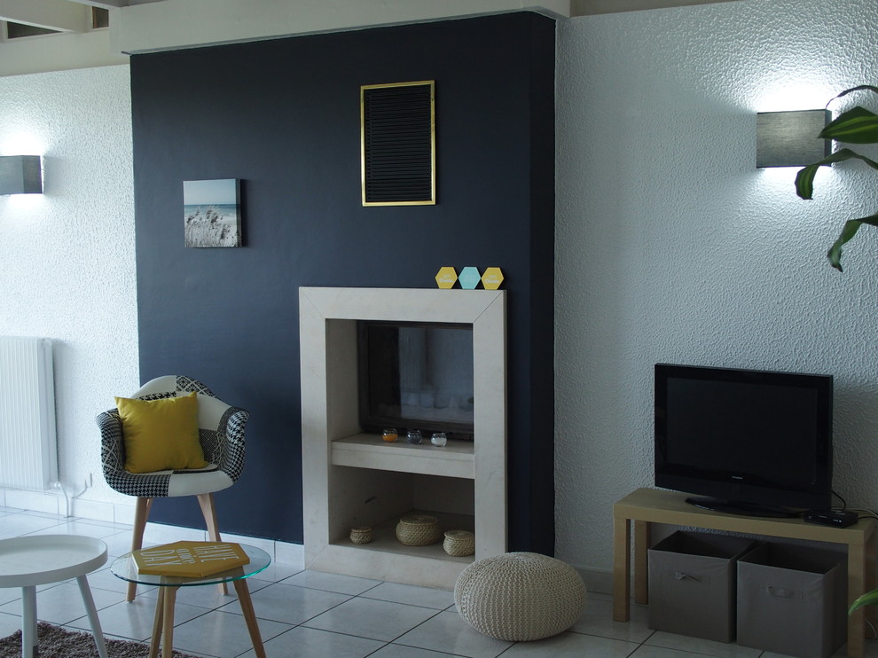 Пример оригинального дизайна: открытая гостиная комната среднего размера в современном стиле с черными стенами, полом из керамической плитки, стандартным камином, отдельно стоящим телевизором и белым полом