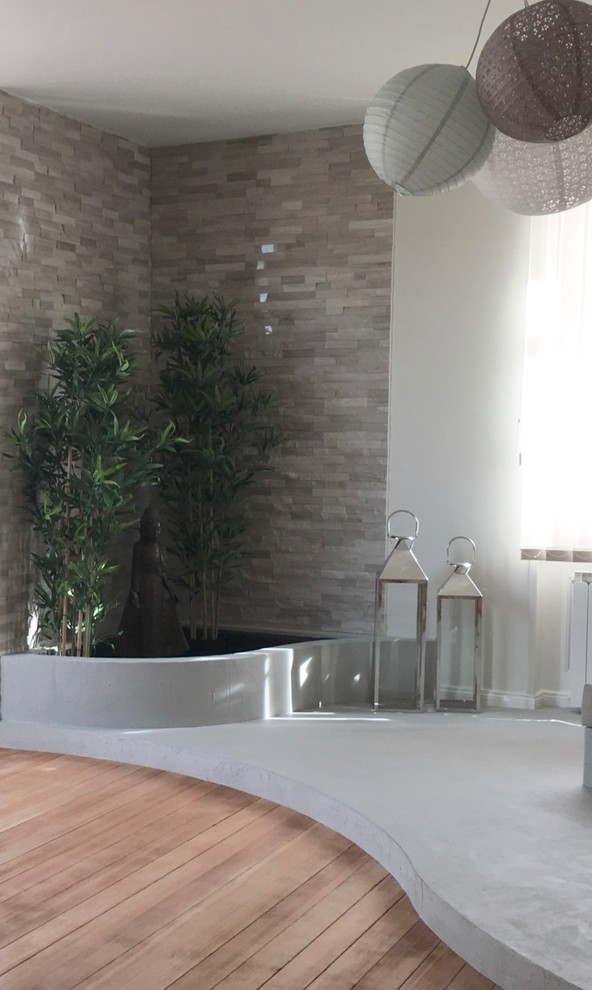 Cette image montre un salon design de taille moyenne et fermé avec un mur beige, parquet clair, un téléviseur indépendant et un sol marron.