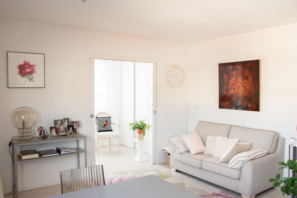 Cette image montre un salon style shabby chic de taille moyenne et ouvert avec un mur rose, sol en stratifié et un téléviseur indépendant.