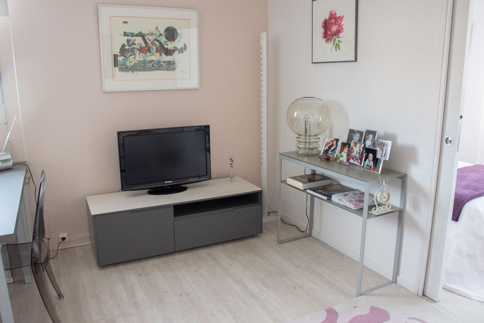 Medium sized romantic open plan living room in Lyon with pink walls, laminate floors and a freestanding tv.