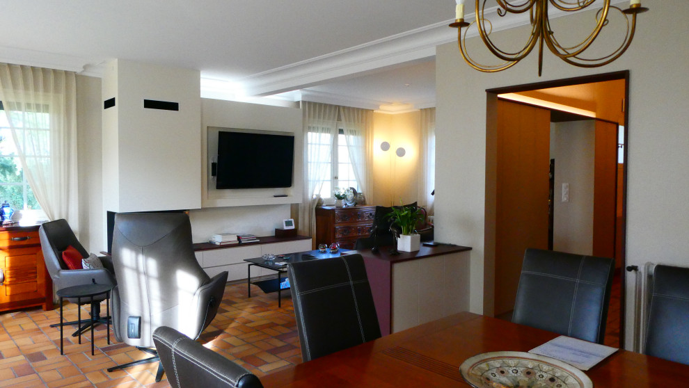 Immagine di un soggiorno design di medie dimensioni e aperto con pavimento in terracotta e TV a parete