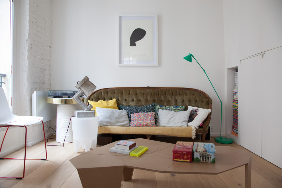 На фото: изолированная гостиная комната среднего размера в стиле фьюжн с с книжными шкафами и полками, белыми стенами и светлым паркетным полом без камина, телевизора