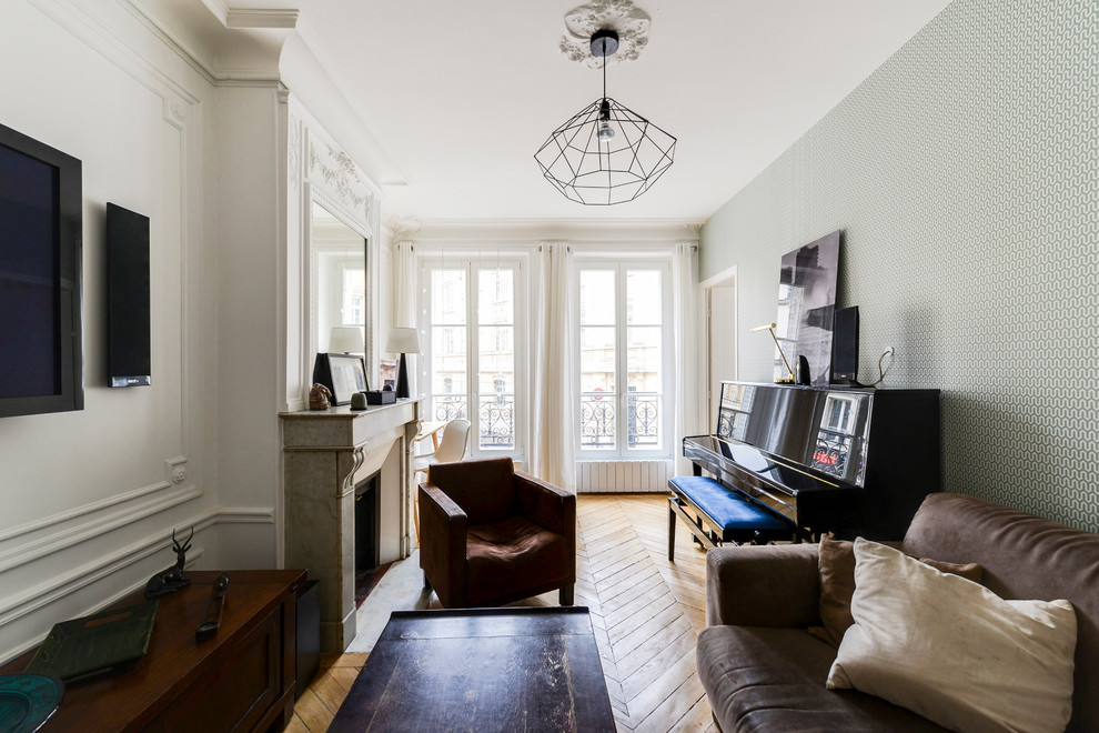 Example of a mid-sized transitional enclosed light wood floor and brown floor living room design in Paris with white walls, a standard fireplace, a wall-mounted tv and a stone fireplace