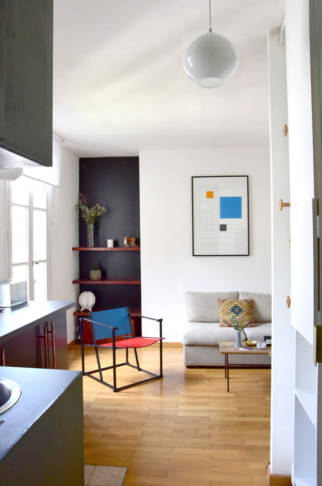 Kleines, Abgetrenntes Eklektisches Wohnzimmer ohne Kamin mit weißer Wandfarbe, braunem Holzboden und TV-Wand in Paris