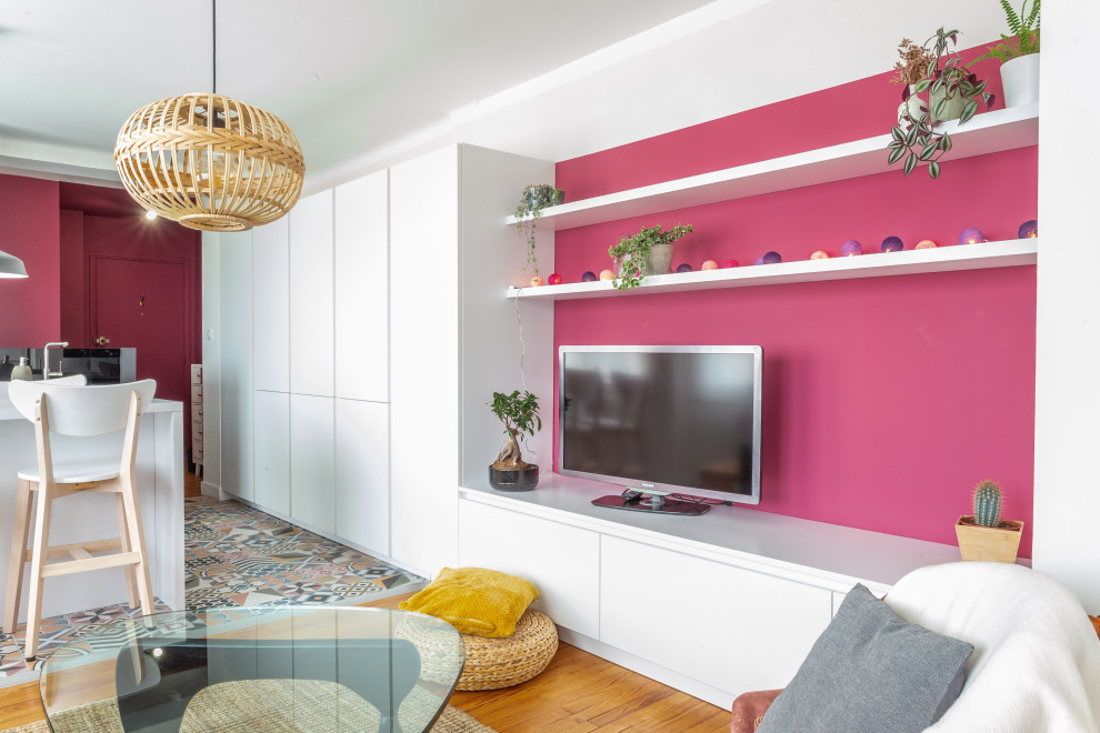 Ejemplo de salón abierto contemporáneo de tamaño medio sin chimenea con paredes rosas, suelo de madera clara y televisor colgado en la pared