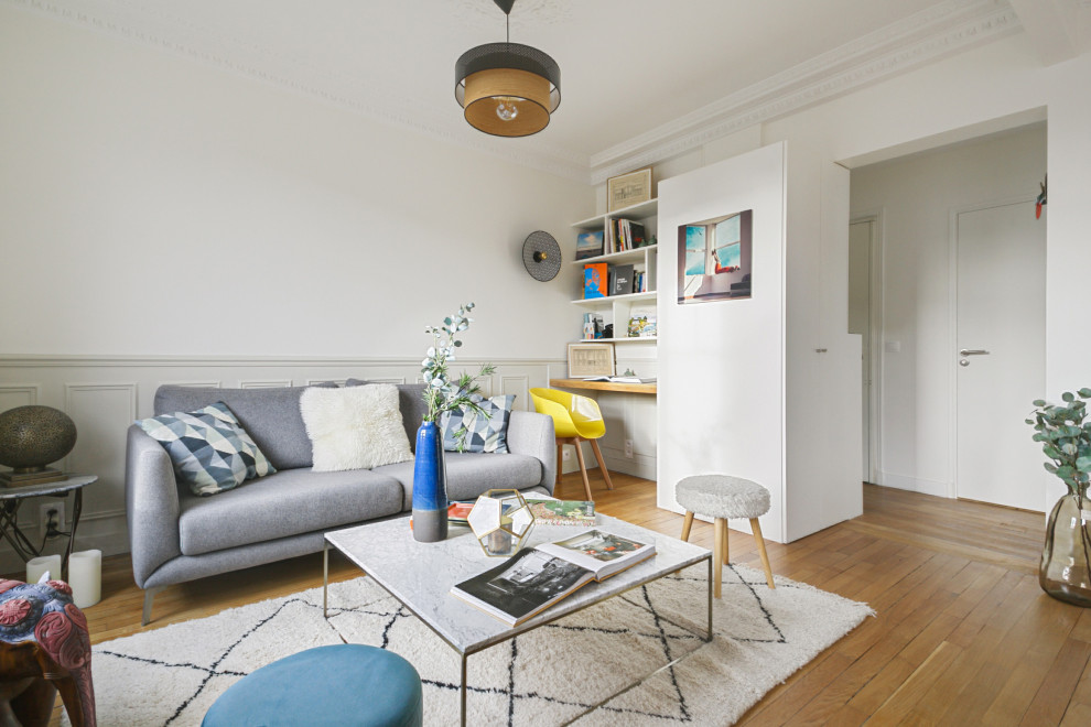 Ispirazione per un soggiorno contemporaneo di medie dimensioni e aperto con pareti beige, parquet chiaro e TV nascosta
