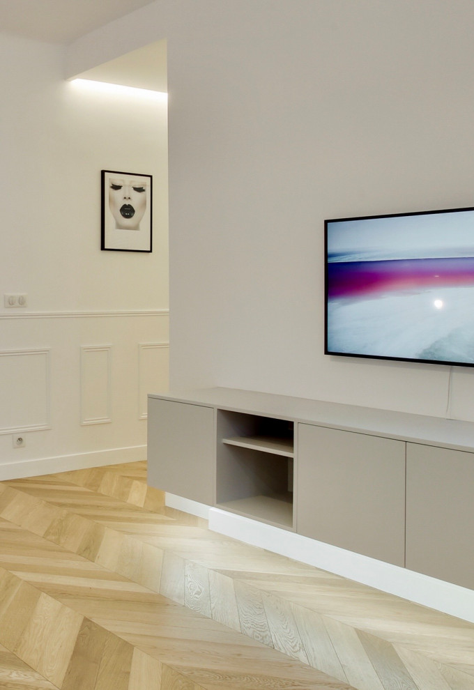 На фото: открытая гостиная комната среднего размера в современном стиле с белыми стенами, светлым паркетным полом, телевизором на стене и панелями на стенах