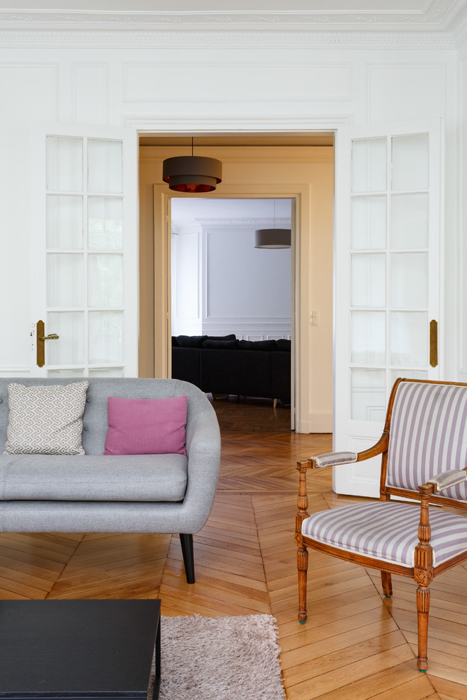 Modelo de salón abierto escandinavo grande sin chimenea con paredes blancas, suelo de madera en tonos medios, televisor independiente y suelo marrón