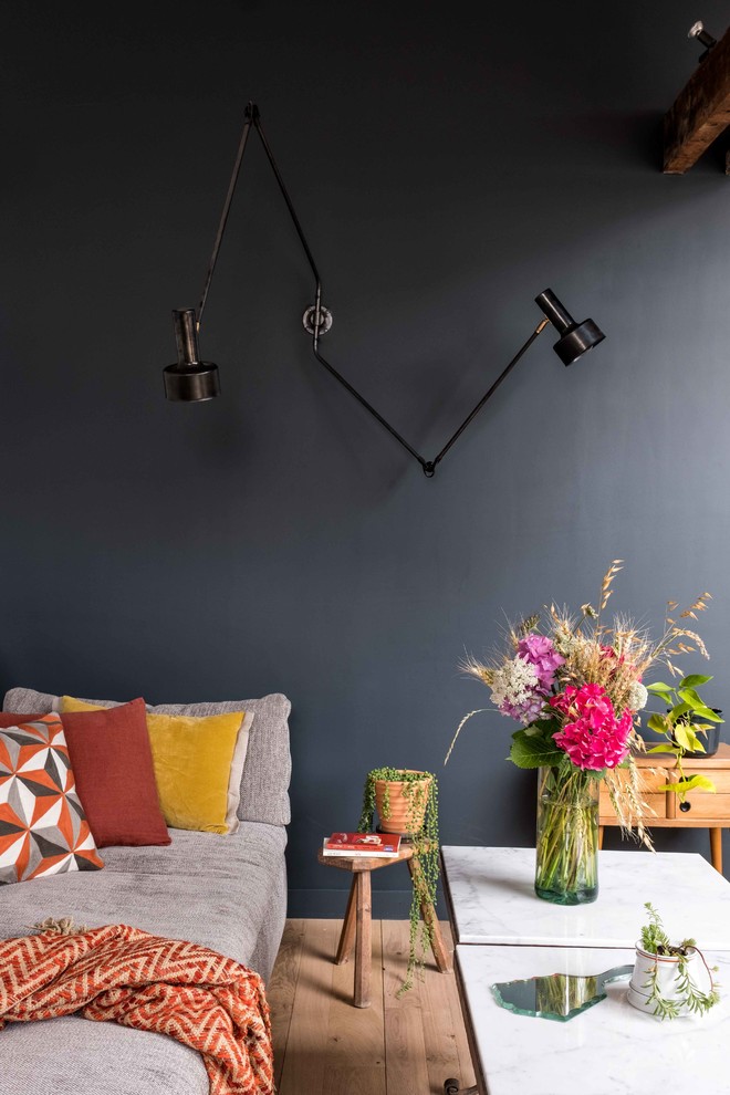 Mittelgroßes, Offenes Modernes Wohnzimmer mit blauer Wandfarbe, hellem Holzboden, freistehendem TV und beigem Boden in Paris