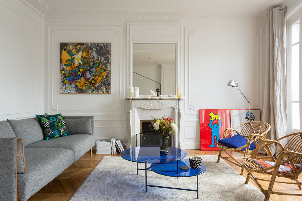 パリにあるコンテンポラリースタイルのおしゃれな応接間 (白い壁、無垢フローリング、標準型暖炉、テレビなし、石材の暖炉まわり) の写真