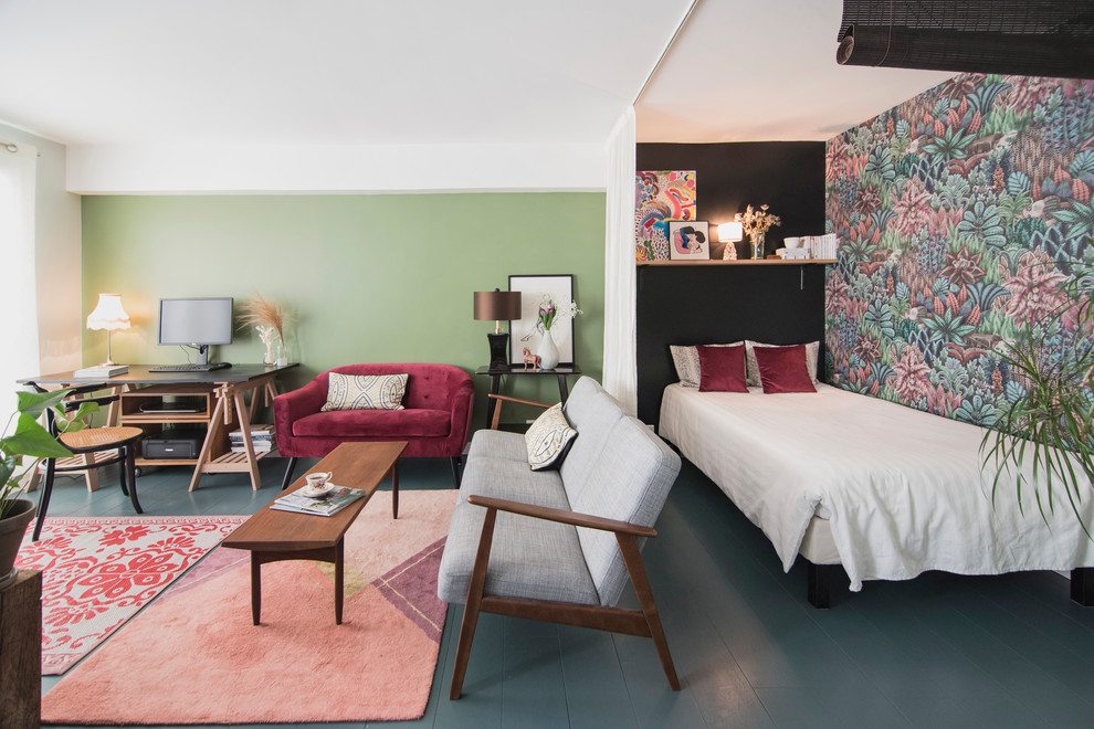 На фото: открытая гостиная комната среднего размера в стиле фьюжн с с книжными шкафами и полками, зелеными стенами, деревянным полом и синим полом с