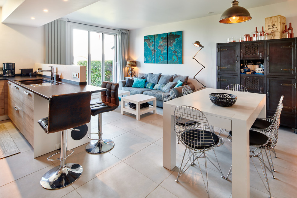 Idee per un soggiorno bohémian aperto con pareti bianche, pavimento con piastrelle in ceramica, TV a parete e pavimento grigio