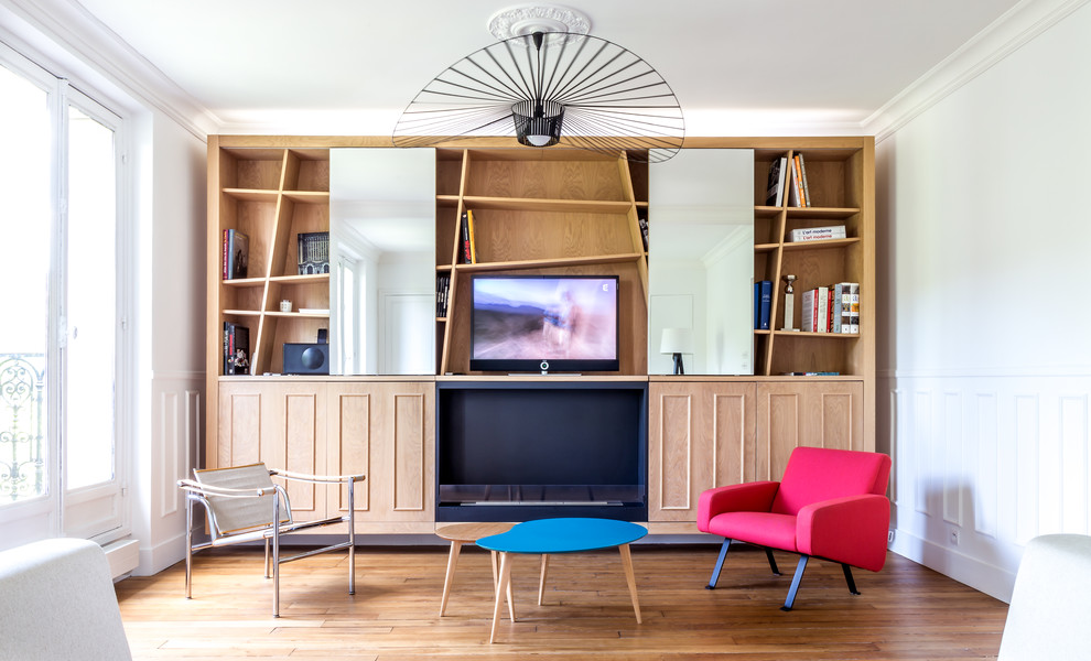 Diseño de biblioteca en casa abierta contemporánea de tamaño medio con paredes blancas, suelo de madera clara, chimeneas suspendidas, marco de chimenea de metal, televisor retractable y suelo marrón