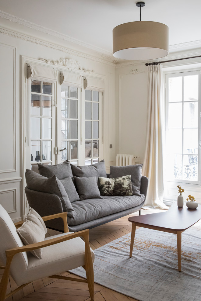 Foto di un soggiorno minimal di medie dimensioni con sala formale, pareti bianche, parquet chiaro e nessuna TV