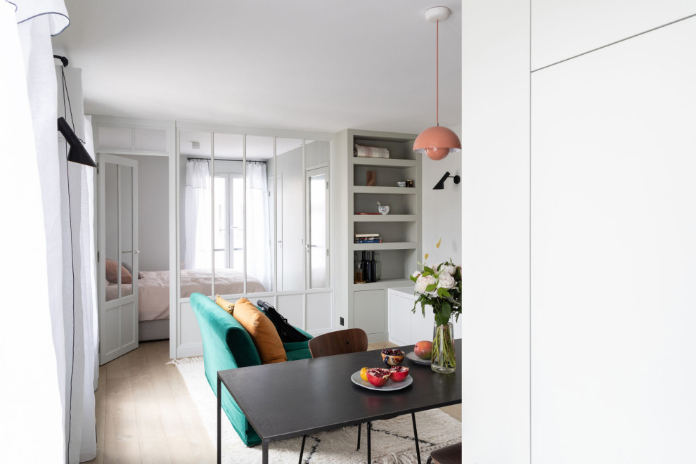 Imagen de salón abierto actual pequeño sin chimenea y televisor con paredes grises, suelo de madera clara y suelo beige