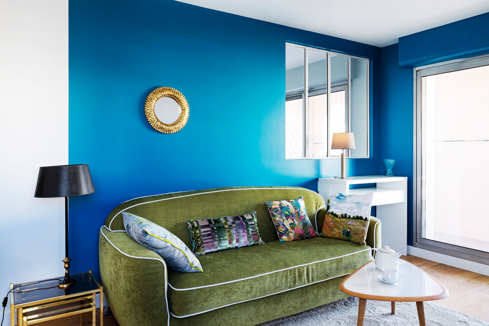 パリにあるお手頃価格の中くらいな北欧スタイルのおしゃれな独立型リビング (青い壁、合板フローリング、暖炉なし、ベージュの床) の写真