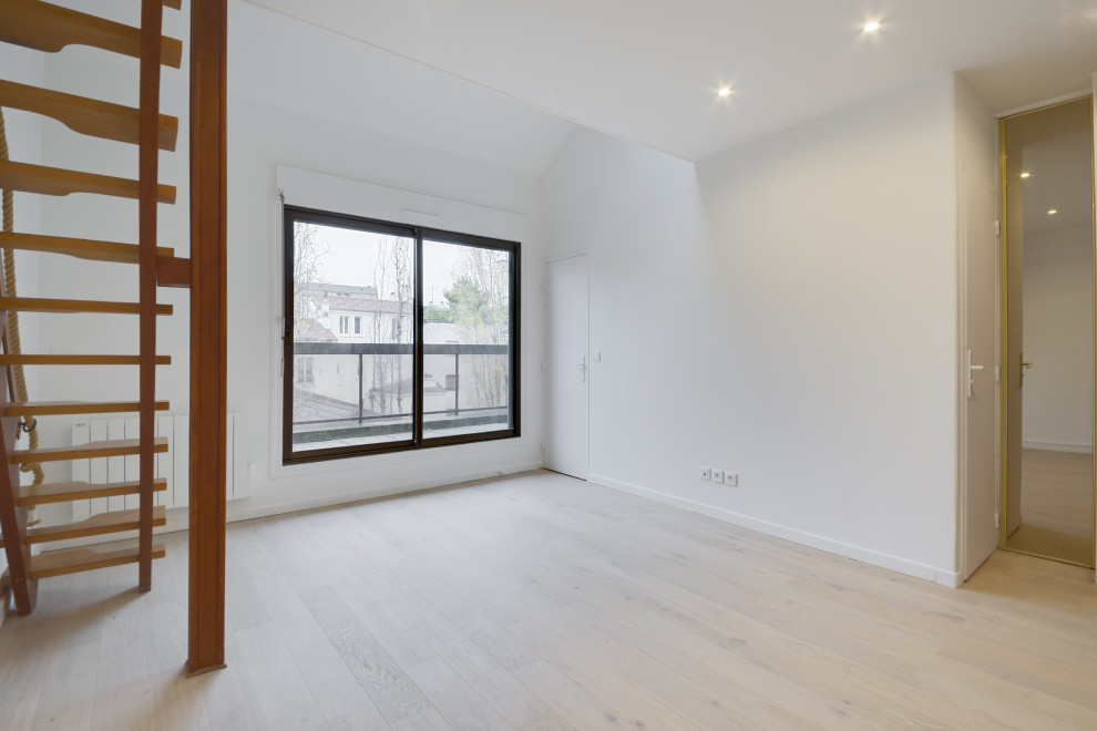 Inspiration för mellanstora moderna loftrum, med vita väggar, ljust trägolv och grått golv