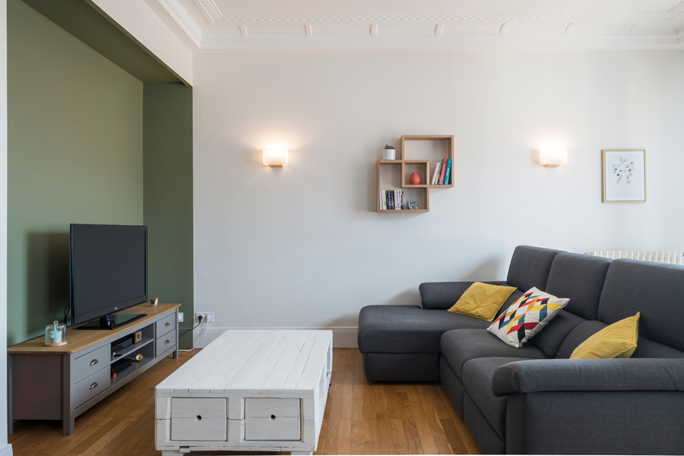 Inspiration pour un salon nordique de taille moyenne et ouvert avec un mur vert, parquet clair et un téléviseur indépendant.