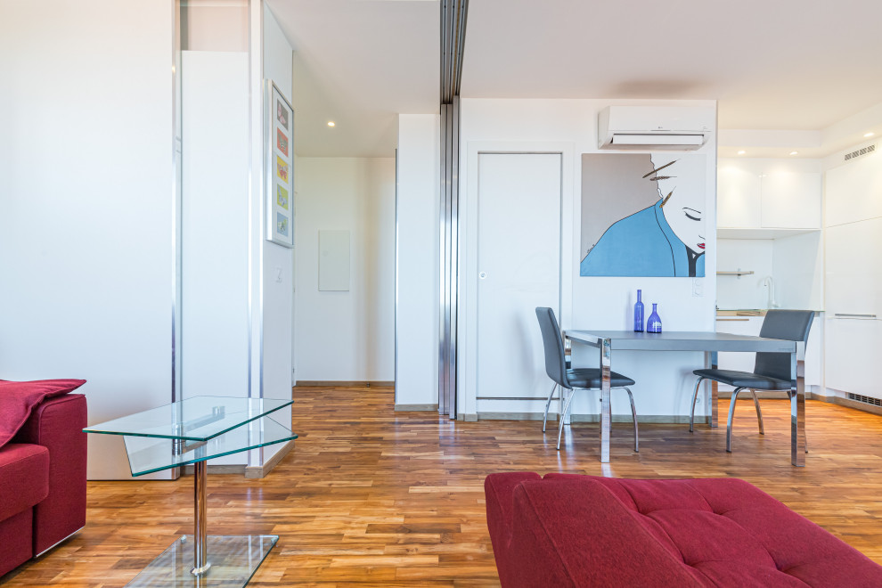 Imagen de salón abierto contemporáneo pequeño con paredes blancas y suelo de madera clara