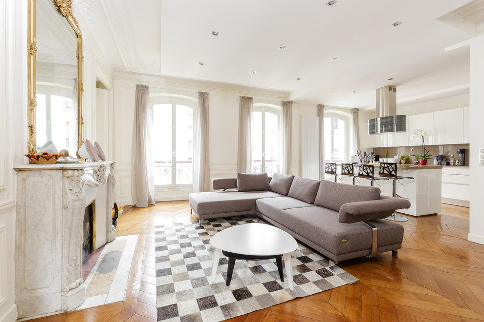 Großes, Offenes Modernes Wohnzimmer mit weißer Wandfarbe, braunem Holzboden, Kamin und Kaminumrandung aus Stein in Paris