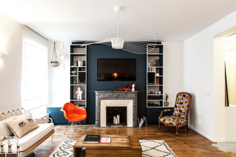 Living room - eclectic medium tone wood floor living room idea in Paris with a standard fireplace and a stone fireplace