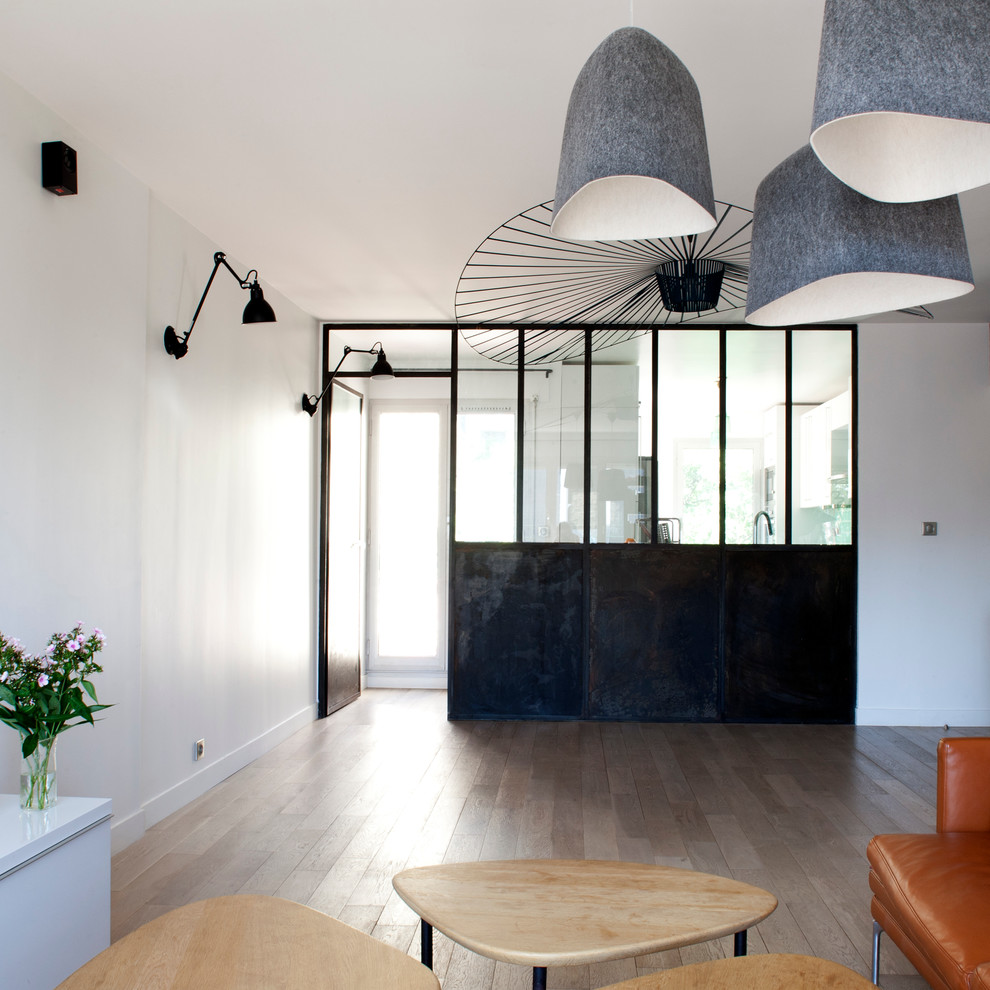 Großes, Offenes Industrial Wohnzimmer ohne Kamin mit weißer Wandfarbe und braunem Holzboden in Paris
