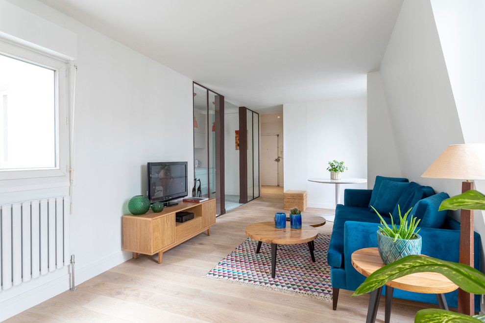 Cette image montre un salon design ouvert avec un mur blanc, parquet clair, un téléviseur indépendant, un sol beige et éclairage.