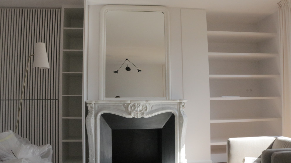 パリにある高級な広いコンテンポラリースタイルのおしゃれなLDK (白い壁、濃色無垢フローリング、標準型暖炉、石材の暖炉まわり、白い床) の写真