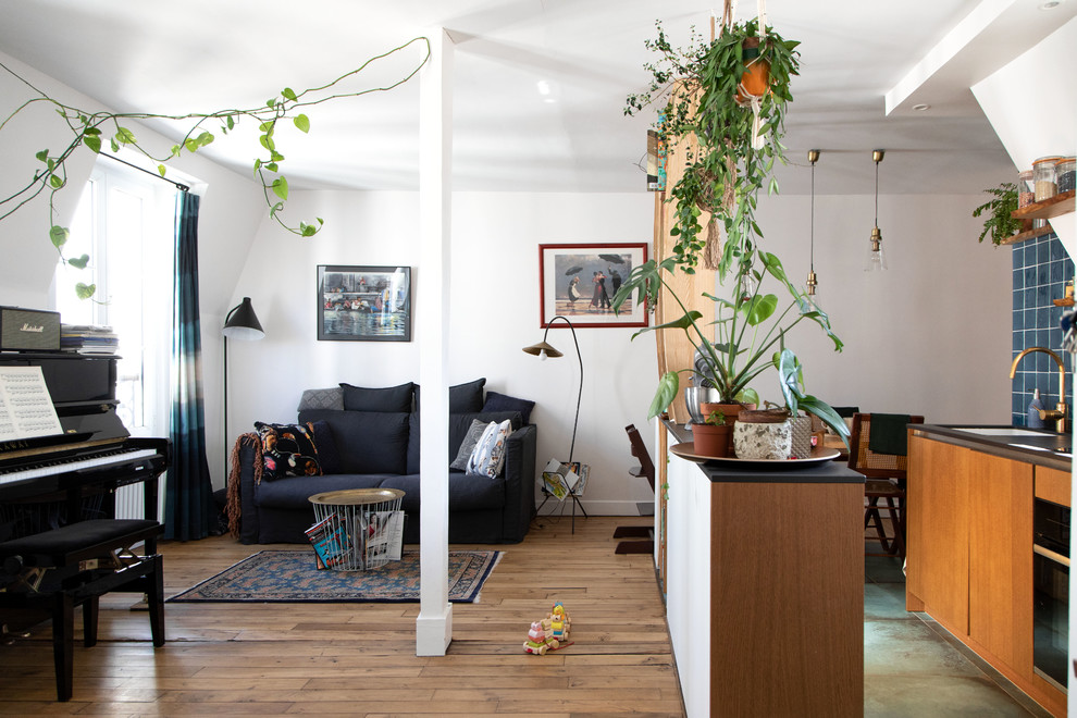Immagine di un piccolo soggiorno eclettico aperto con pareti bianche, pavimento in legno massello medio, pavimento marrone, nessun camino e nessuna TV