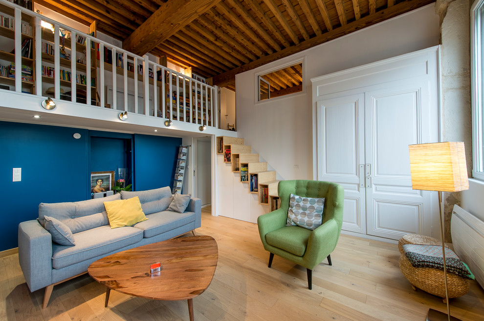 Aménagement d'un salon contemporain avec un mur bleu, parquet clair, un sol beige et éclairage.